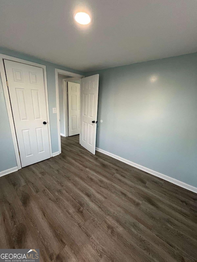 unfurnished bedroom featuring dark hardwood / wood-style floors