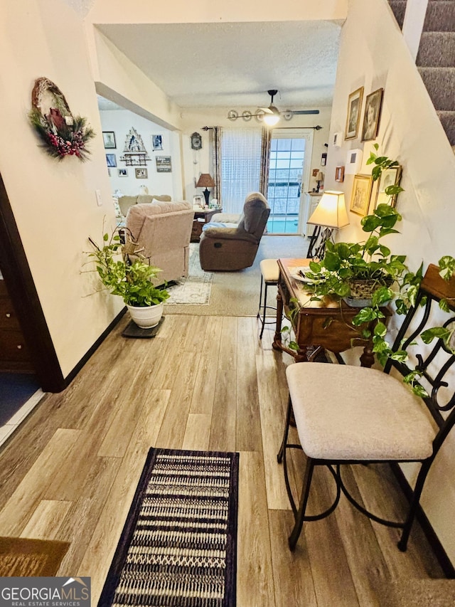 hall with hardwood / wood-style flooring and a textured ceiling