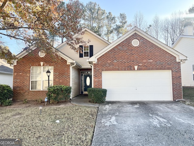 traditional-style home with an attached garage, a front yard, concrete driveway, and brick siding