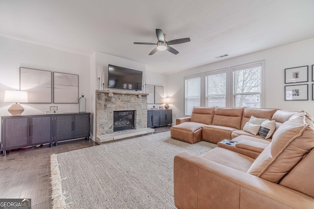 living room with ceiling fan and dark hardwood / wood-style flooring