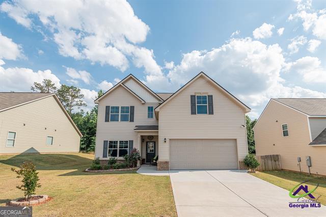 view of front of home with a garage and a front lawn