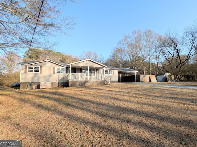 ranch-style home featuring a porch, a carport, and a front lawn