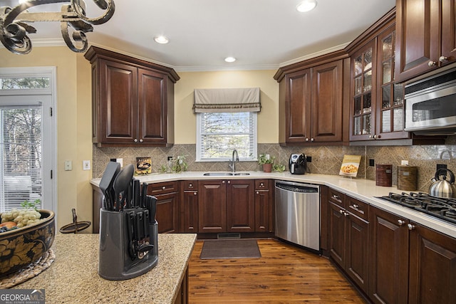 kitchen with sink, ornamental molding, appliances with stainless steel finishes, dark hardwood / wood-style flooring, and decorative backsplash