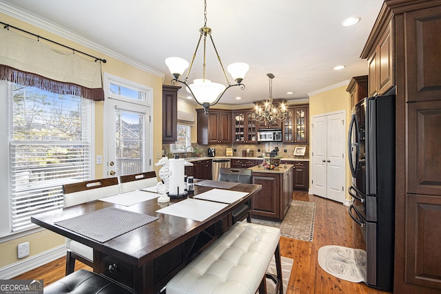 dining space featuring sink, hardwood / wood-style flooring, plenty of natural light, and ornamental molding