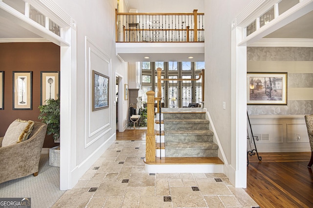 entrance foyer featuring a towering ceiling and ornamental molding