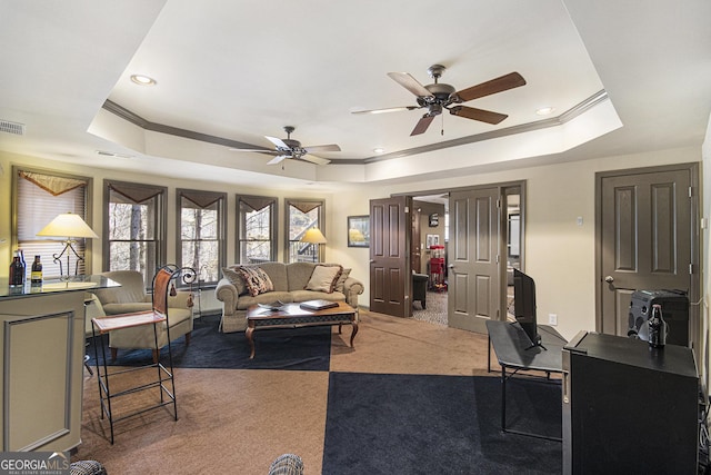 living room featuring crown molding, carpet flooring, a tray ceiling, and ceiling fan