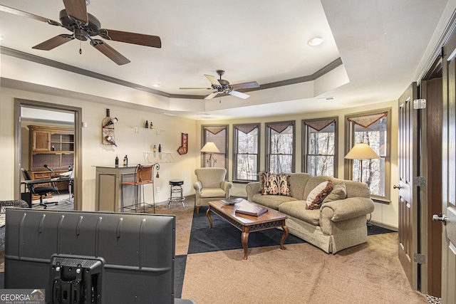 carpeted living room featuring a tray ceiling and crown molding