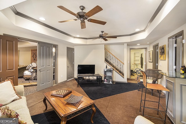 living room featuring ornamental molding, a tray ceiling, and dark colored carpet