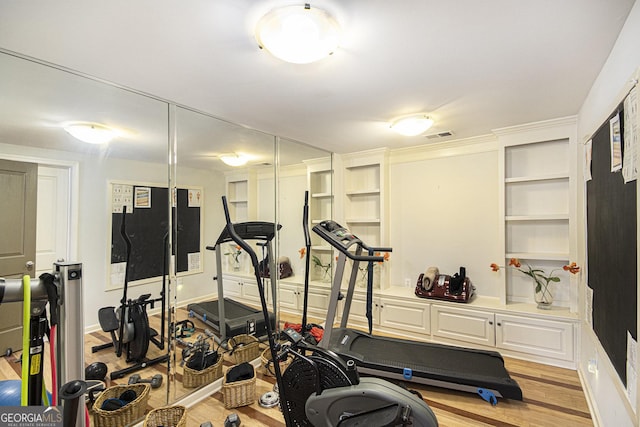 exercise room featuring light wood-type flooring