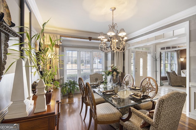 dining space with crown molding, dark hardwood / wood-style floors, and a chandelier