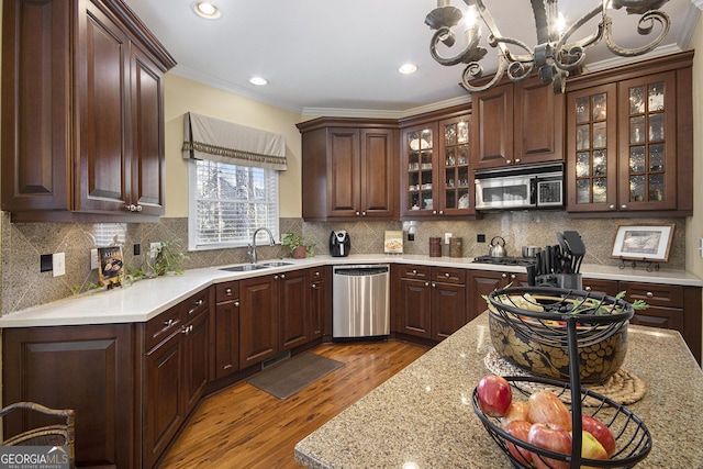 kitchen with sink, appliances with stainless steel finishes, dark hardwood / wood-style floors, dark brown cabinetry, and tasteful backsplash