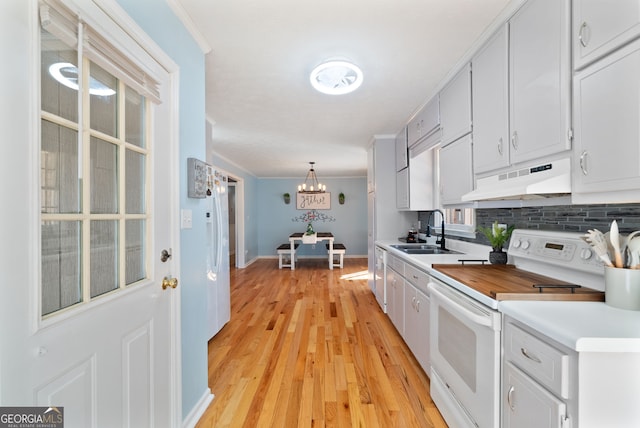 kitchen featuring sink, pendant lighting, crown molding, electric stove, and backsplash