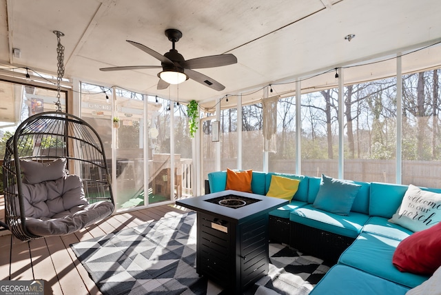 sunroom / solarium featuring plenty of natural light and ceiling fan