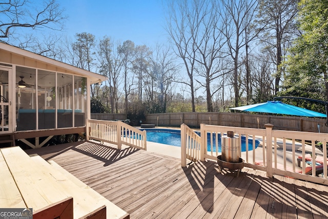 view of pool with a sunroom and a deck