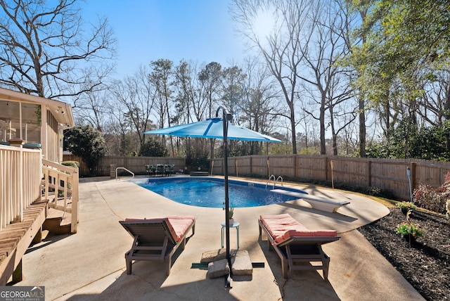 view of swimming pool featuring a diving board and a patio