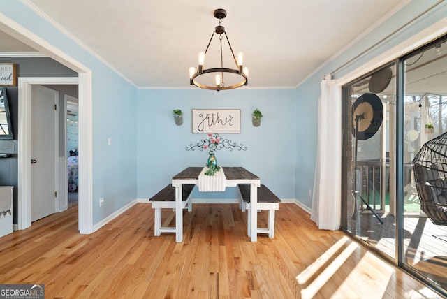 dining room featuring ornamental molding, light hardwood / wood-style floors, and a chandelier