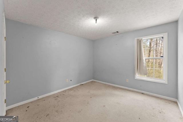 carpeted spare room featuring a textured ceiling