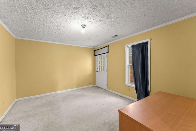 carpeted empty room featuring ornamental molding and a textured ceiling