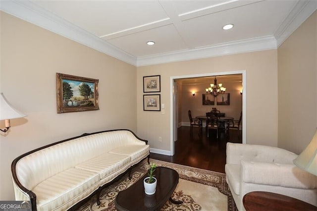 sitting room featuring hardwood / wood-style flooring, ornamental molding, coffered ceiling, and an inviting chandelier