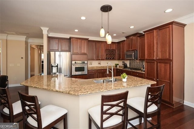 kitchen with appliances with stainless steel finishes, a large island, a breakfast bar, and sink