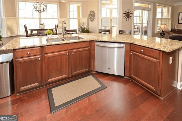 kitchen with sink, hanging light fixtures, stainless steel dishwasher, light stone countertops, and an inviting chandelier