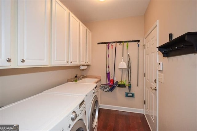 laundry area with cabinets, washer and dryer, sink, and dark hardwood / wood-style floors