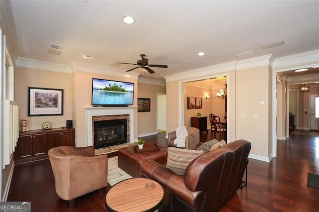 living room with dark hardwood / wood-style flooring, ceiling fan with notable chandelier, and ornamental molding