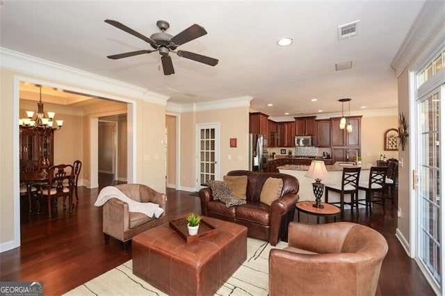 living room with dark hardwood / wood-style flooring, crown molding, and ceiling fan with notable chandelier