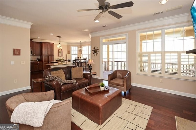 living room with ornamental molding, dark wood-type flooring, and ceiling fan