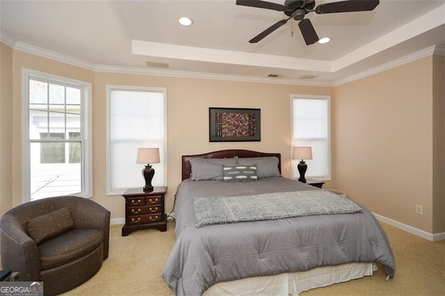 bedroom featuring crown molding, light colored carpet, and a tray ceiling