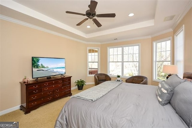 bedroom featuring light carpet, a tray ceiling, ornamental molding, and ceiling fan