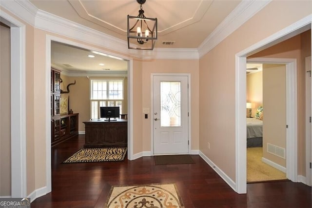 doorway to outside featuring crown molding, dark hardwood / wood-style floors, and a chandelier