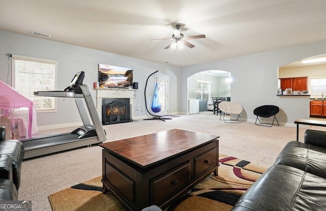 carpeted living room with ceiling fan