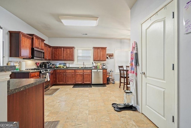 kitchen with stainless steel appliances, sink, and backsplash