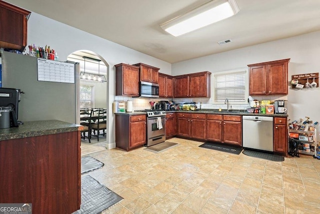 kitchen featuring tasteful backsplash, sink, and appliances with stainless steel finishes