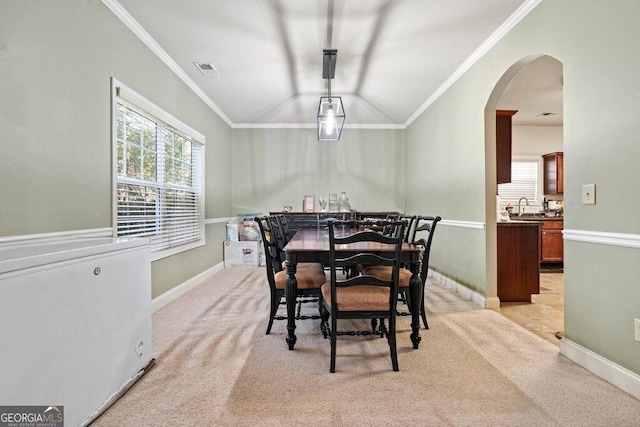 dining area with ornamental molding, sink, and light carpet