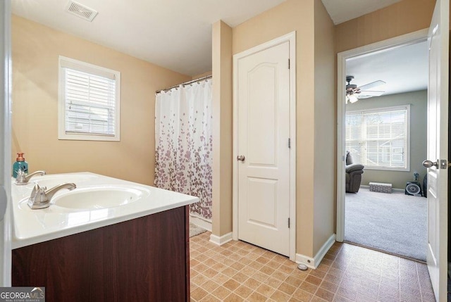 bathroom with vanity, ceiling fan, and walk in shower