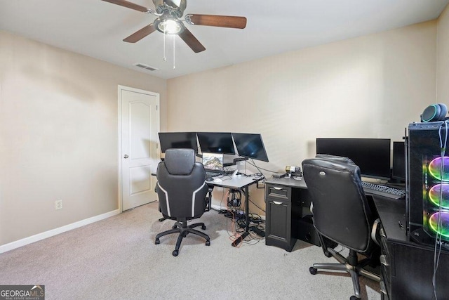 carpeted home office featuring ceiling fan