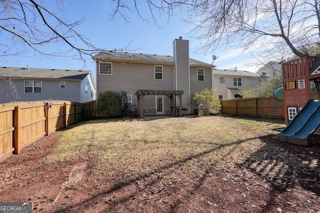 back of house with a pergola, a lawn, and a playground