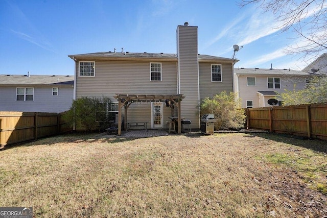 back of property featuring a yard and a pergola