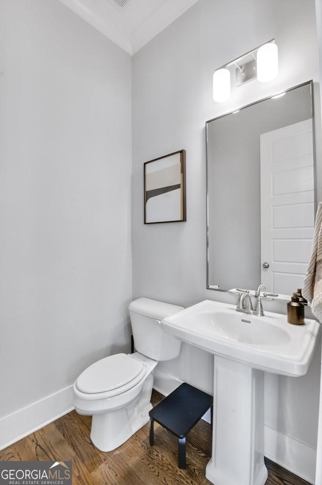 bathroom featuring hardwood / wood-style flooring and toilet