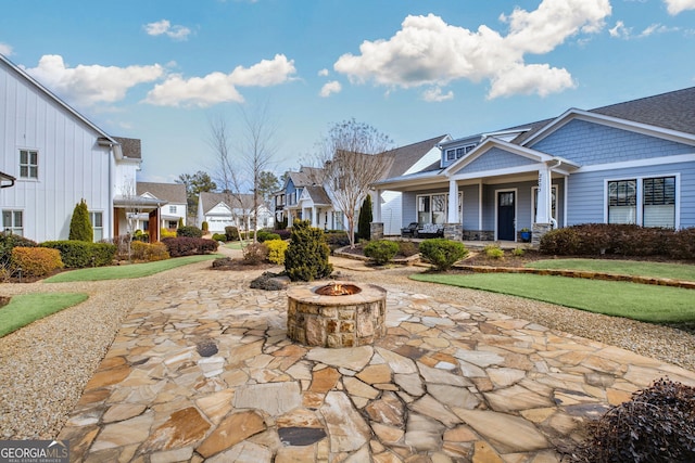 view of community featuring an outdoor fire pit and a patio area