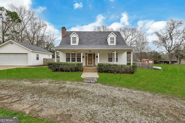 new england style home with a garage, an outdoor structure, a front yard, and covered porch