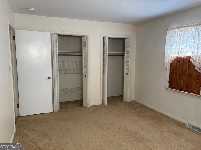 living room featuring heating unit, electric panel, and brick wall