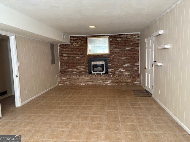 unfurnished living room featuring baseboards, brick wall, a wood stove, and heating unit