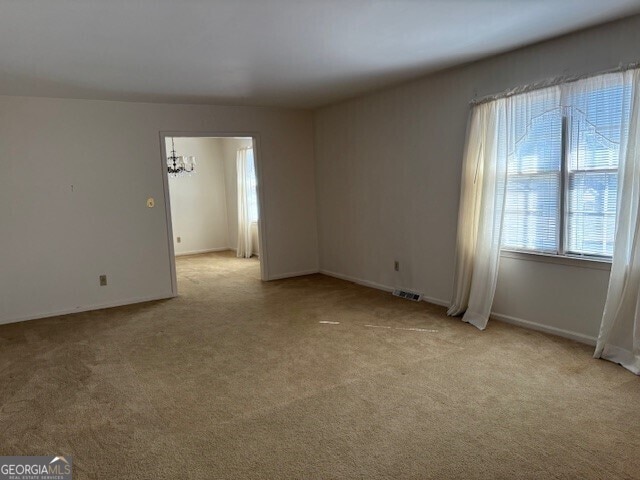 unfurnished room with light carpet and visible vents