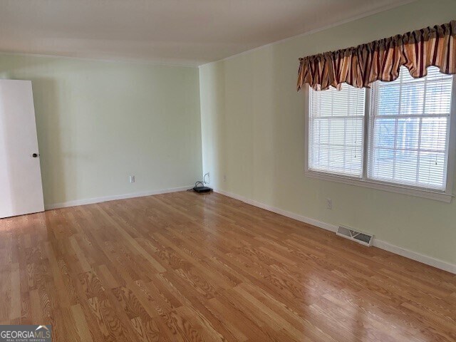 carpeted empty room featuring an inviting chandelier