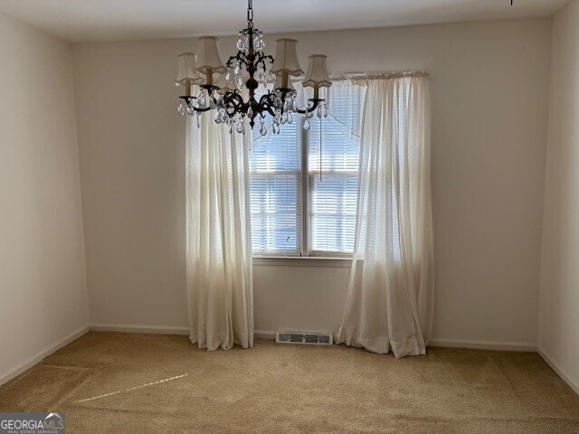 spare room with light carpet, visible vents, and baseboards