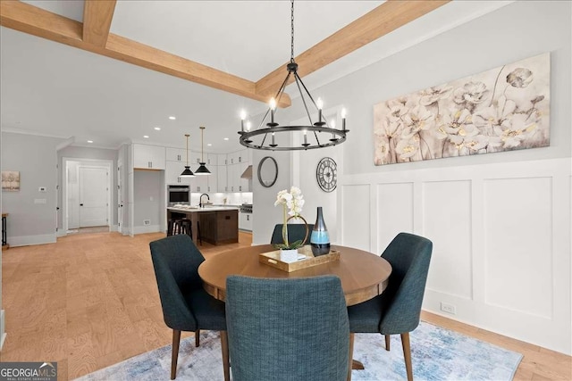 dining area with an inviting chandelier, sink, light hardwood / wood-style flooring, and beamed ceiling