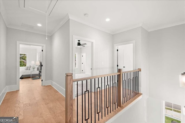 corridor with ornamental molding and light hardwood / wood-style floors